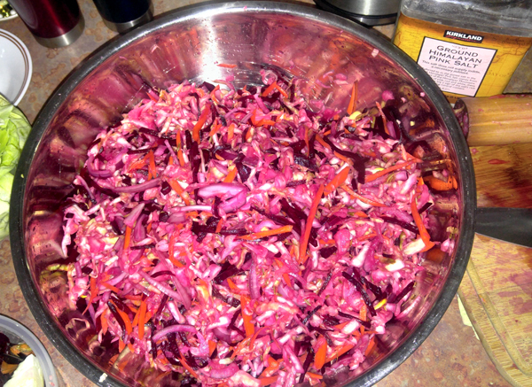 making sauerkraut with cabbage, carrtos, beets and red onion